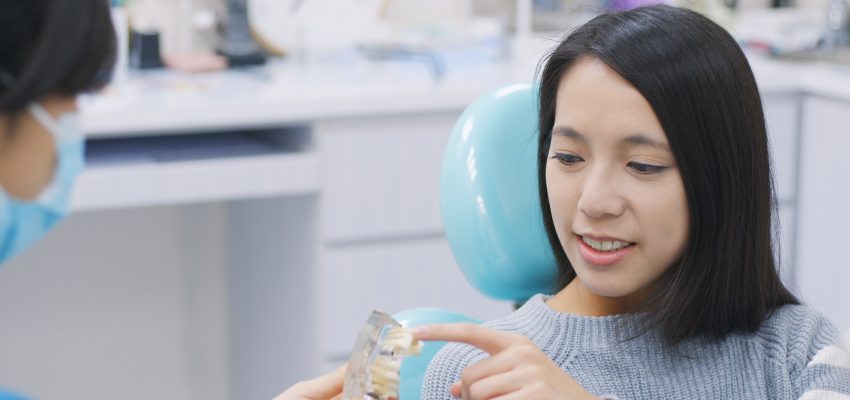 Dentist showing the implant tooth to the patient